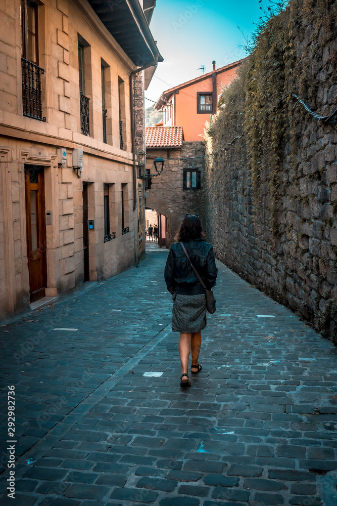 Pasaia San Juan, Gipuzkoa / Spain »; September 22, 2019: A young woman walking towards the tunnel of the historic center of San Juan Pasaia San Juan, Gipuzkoa / Spain »; September 22, 2019: A young woman walking towards the tunnel of the historic center of San Juan