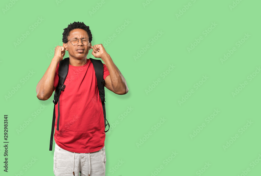 Young man worried about loud noises and covering his ears Young man worried about loud noises and covering his ears
