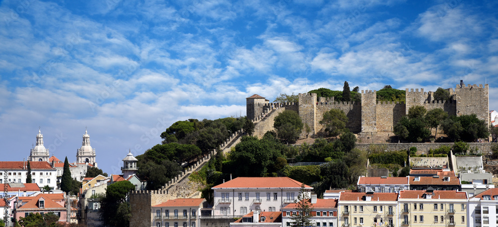 View of Sao Jorge Castle (Saint George Castle, Castelo de Sao Jorge) and old buildings at the historical Alfama district in downtown Lisbon, Portugal