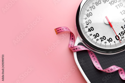 Fotografie Scales and measuring tape on color background