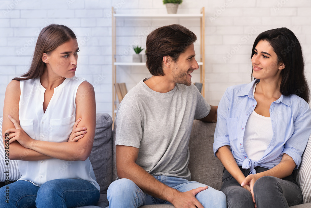 Envious Girl Looking At Flirting Couple Sitting On Sofa Indoor Envious Girl Looking At Flirting Couple Sitting On Sofa Indoor