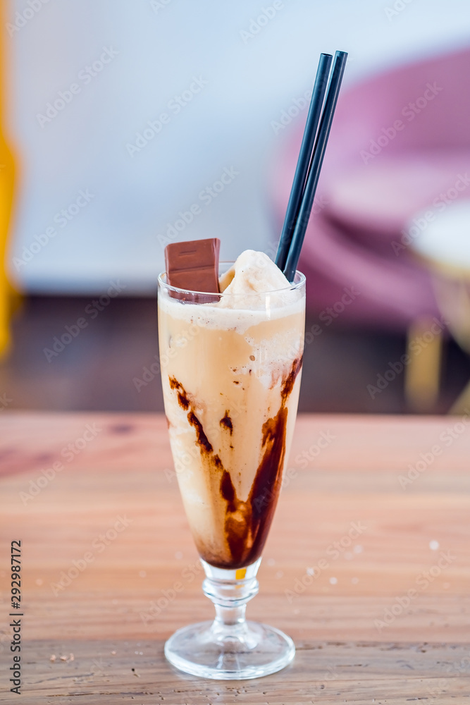Glass of chocolate milkshake with tasty whipped cream and piece of chocolate. Glass of chocolate milkshake with tasty whipped cream and piece of chocolate.
