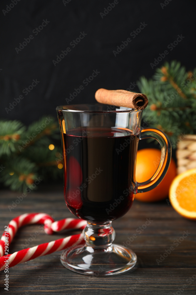 Glass of tasty mulled wine on decorated wooden background, space for text Glass of tasty mulled wine on decorated wooden background, space for text