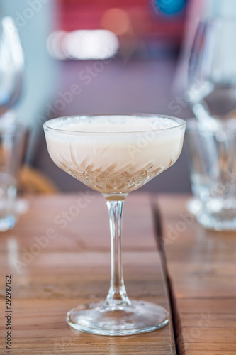 Close-up of banana milk cocktail served in a champagne glass.