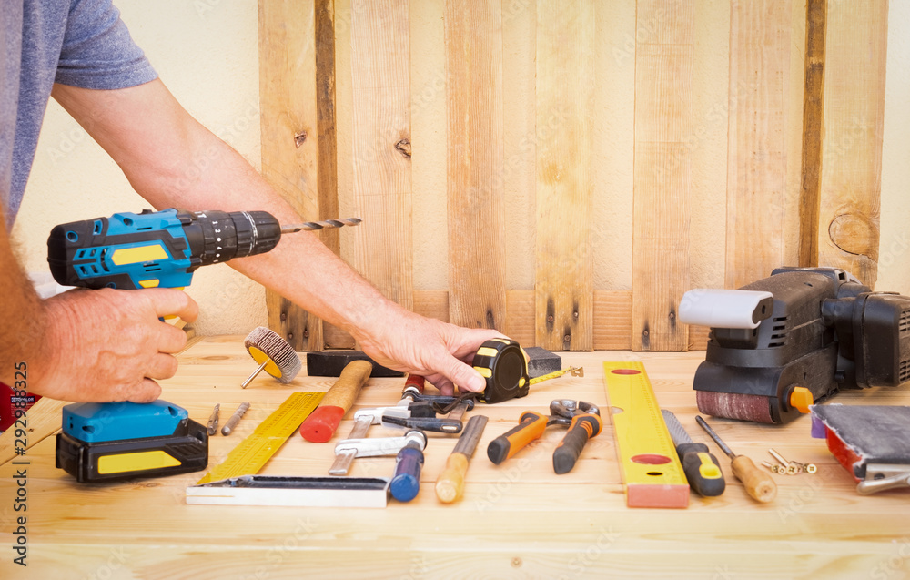 Hands of an elderly people with white hair and eyeglasses enjoying at his hobby working with pallets and recycled wood. Senior man Hands of an elderly people with white hair and eyeglasses enjoying at his hobby working with pallets and recycled wood. Senior man