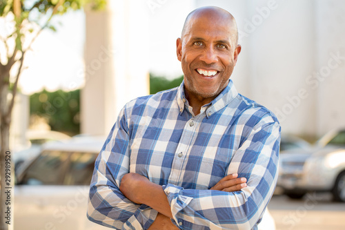 Happy mature African American man smiling outside.