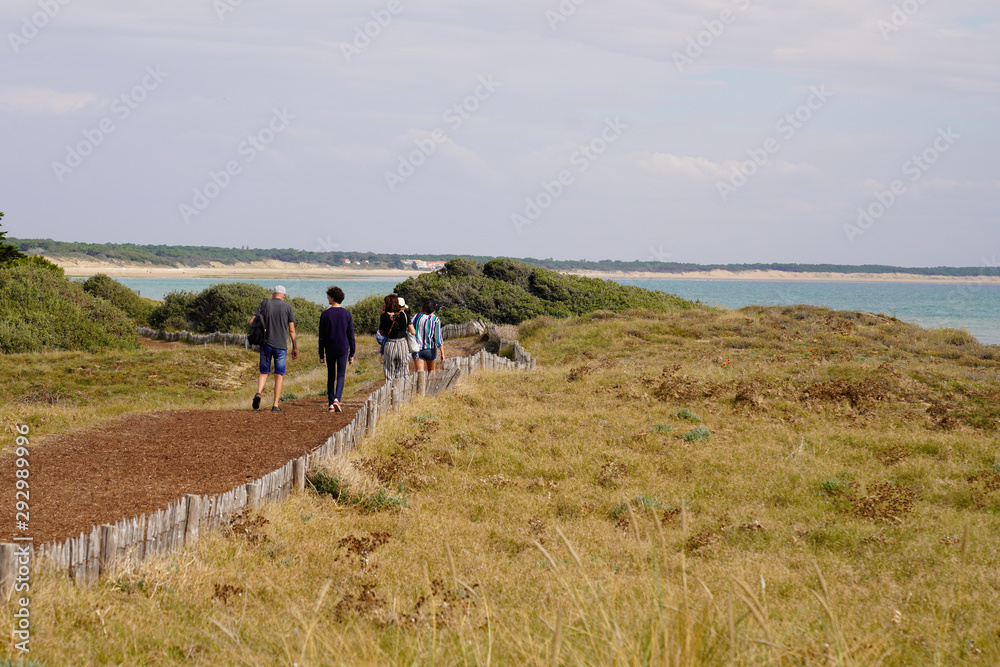 family back view behind walk path in St Vincent sur Jard in Vendée seacoast