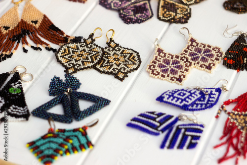 A lot of multi-colored earrings from beads, beautiful and bright ornaments with a pattern, handmade, background