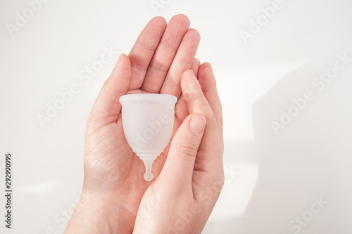 Eco-friendly hypelergenic gynecological silicone menstrual cup for women. Hygienic silicone bowl for collecting menstrual blood in the hands on a white background. Save money.