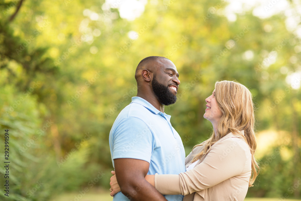 Loving mixed race couple hugging and laughing. Loving mixed race couple hugging and laughing.