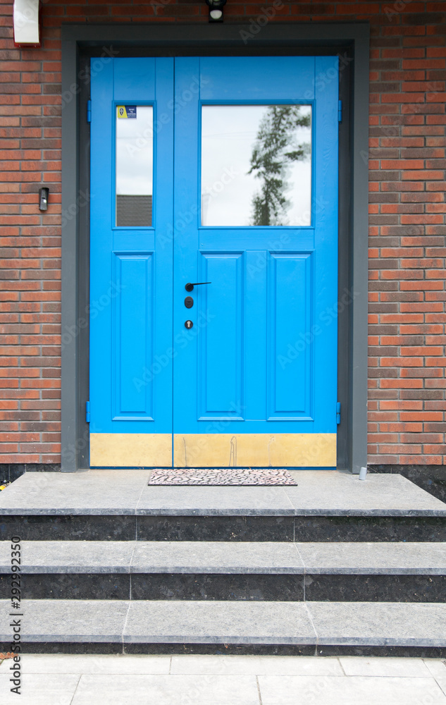 Original blue entrance door on the background of decorative masonry