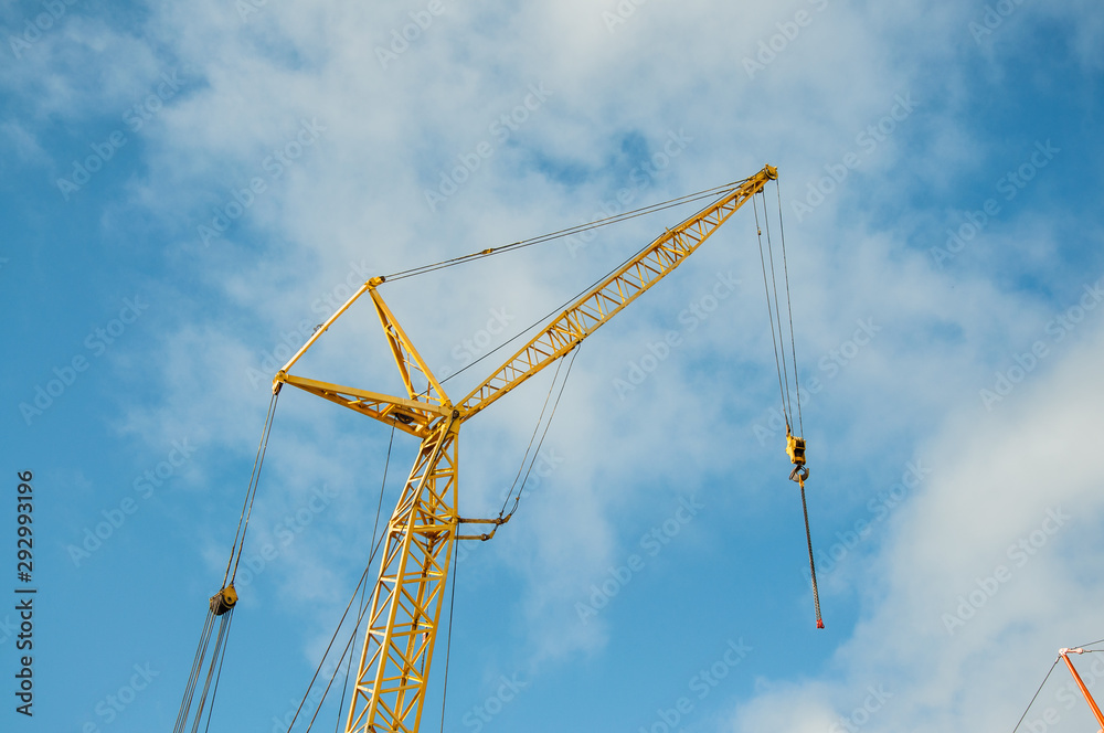 A small construction crane on a background of blue sky. Equipment for the construction of buildings.