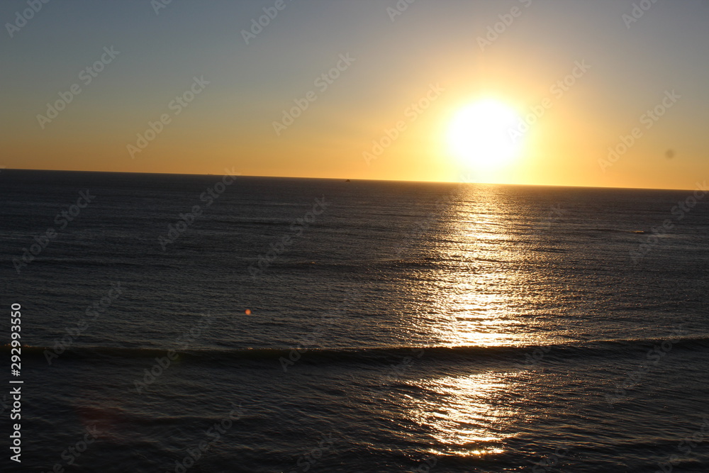 Obraz premium sea ​​scene with sun hiding on the horizon at sunset