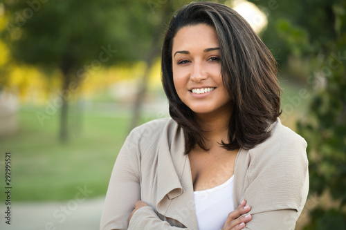 Young confident happy Hispanic woman smiling outside. photo