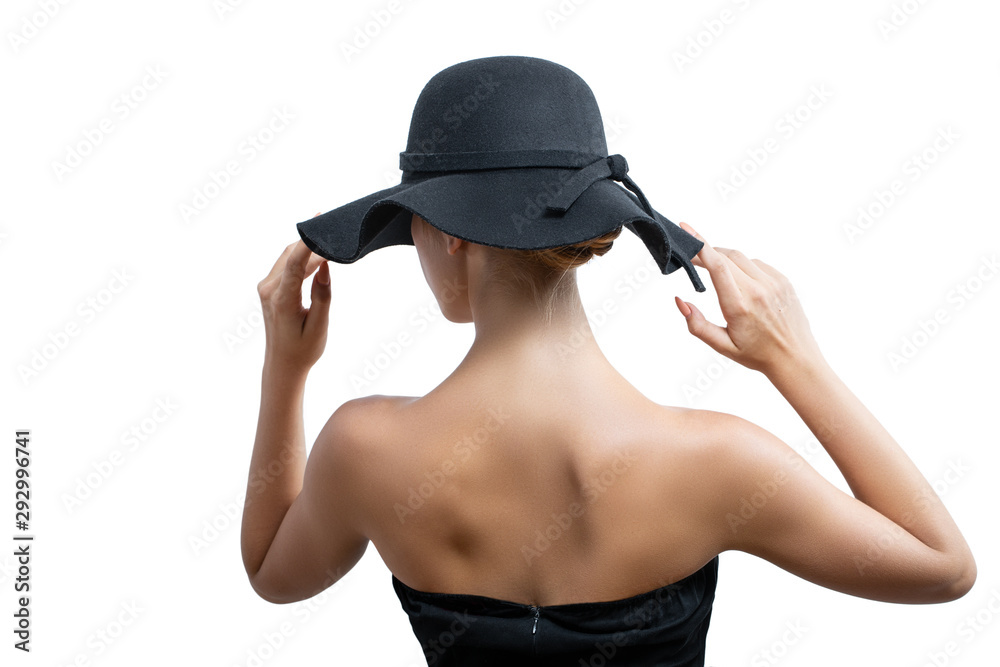 girl in a black hat posing standing back. white background, hands holding the edge of the hat girl in a black hat posing standing back. white background, hands holding the edge of the hat