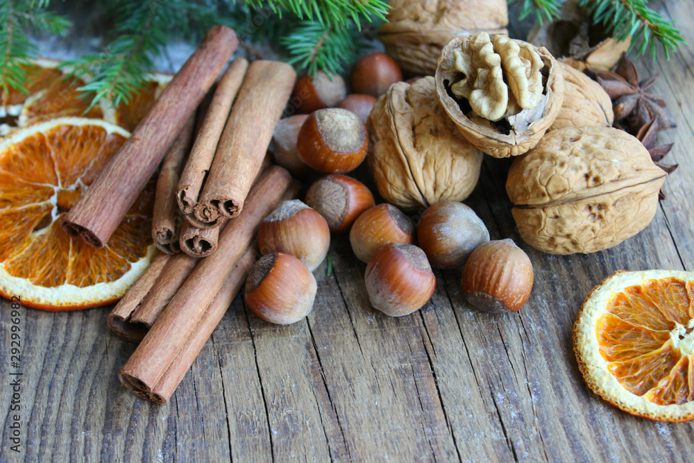 Christmas decor. Christmas spices. Cinnamon sticks, anise stars, walnuts, hazelnuts, dried orange on an old wooden background, copy space. Christmas decor. Christmas spices. Cinnamon sticks, anise stars, walnuts, hazelnuts, dried orange on an old wooden background, copy space.