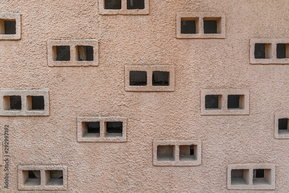 abstract background of ventilated windows in a relief plastered wall