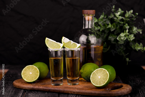 Mexican Gold Tequila with lime and salt on black background with copyspace.