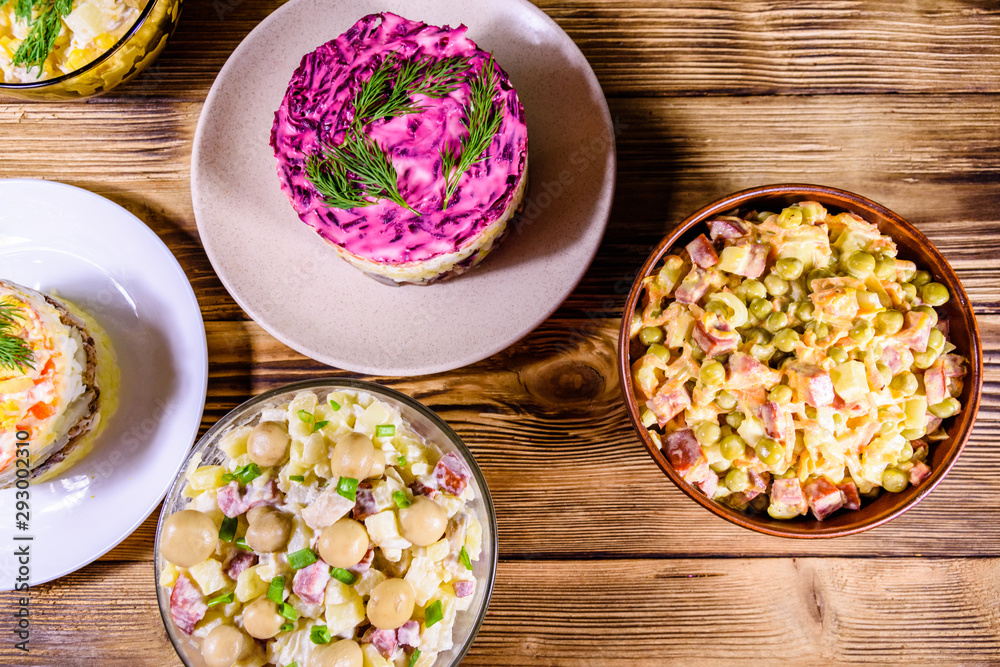 Set of festive mayonnaise salads on wooden table. Top view Set of festive mayonnaise salads on wooden table. Top view