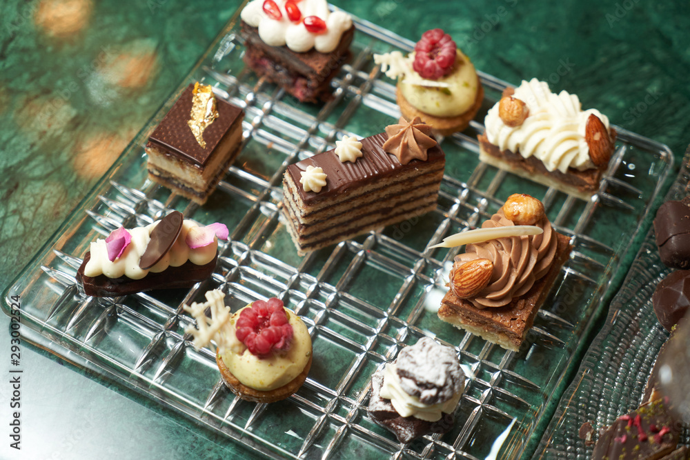 Naklejka premium Dessert plate with assortment of sweets, piece of cake, cookies, biscuits