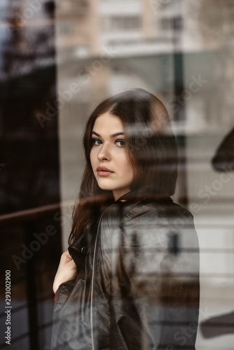 Portrait of beautiful woman, captured through the window glass