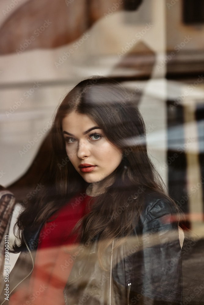 Fototapeta premium Portrait of beautiful woman, captured through the window glass