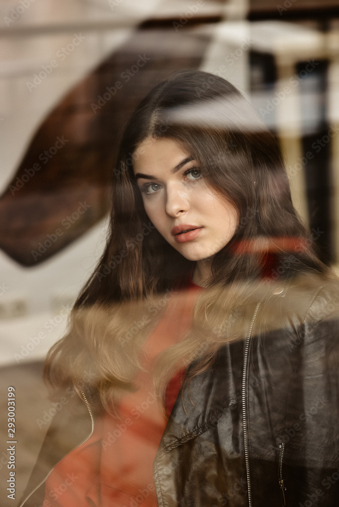 Portrait of beautiful woman, captured through the window glass Portrait of beautiful woman, captured through the window glass