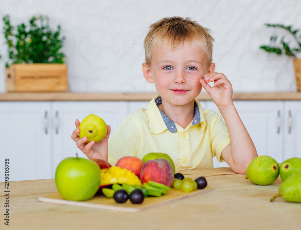 Fototapeta premium Happy little boy eating fresh fruits