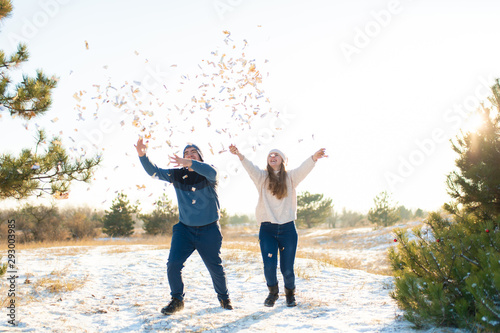 The guy with the girl throw confetti in the winter forest