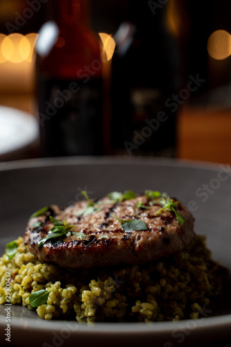 Close up of turkey chop with quinoa on dark blurred background