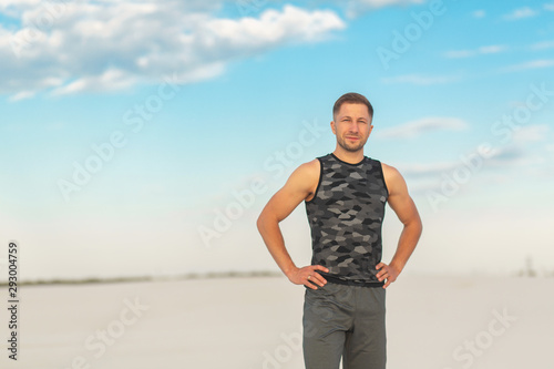 Fitness man doing exercises in sand desert. Sport concept.