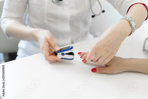 doctor puts a heart rate monitor on a patients finger