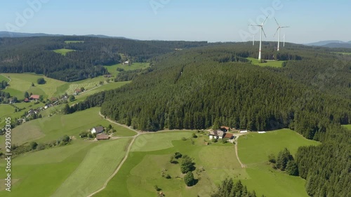 Aerial view of the village Sankt Georgen in Germany  in the black forest on a sunny day in summer. Pan to the right around the turbines. photo