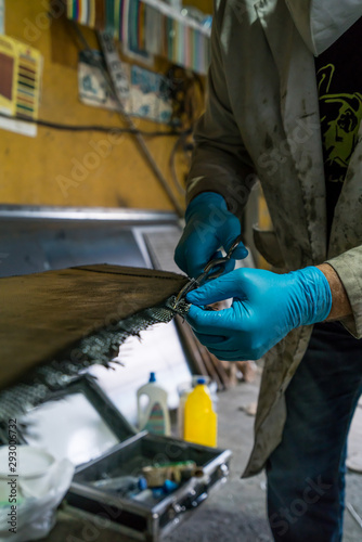 Man with protections on hands  eyes and mask  repairing a piece of carbon and epoxy resin.