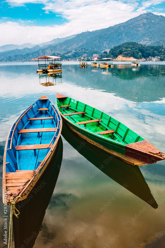 Colourful boats at shore of beautiful Phewa lake. Pokhara, Nepal with Annapurna range in background. 