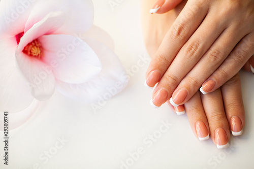 Beautiful woman's nails with french manicure, in beauty studio