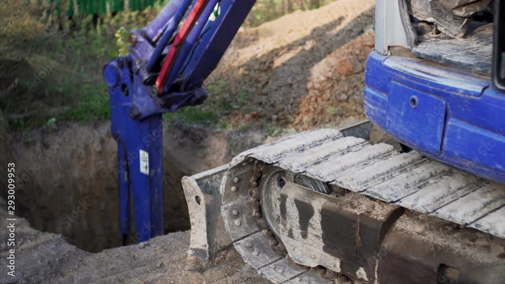 Excavator tracks are boosting a little because of stony soil while digging a hole at construction site Excavator tracks are boosting a little because of stony soil while digging a hole at construction site