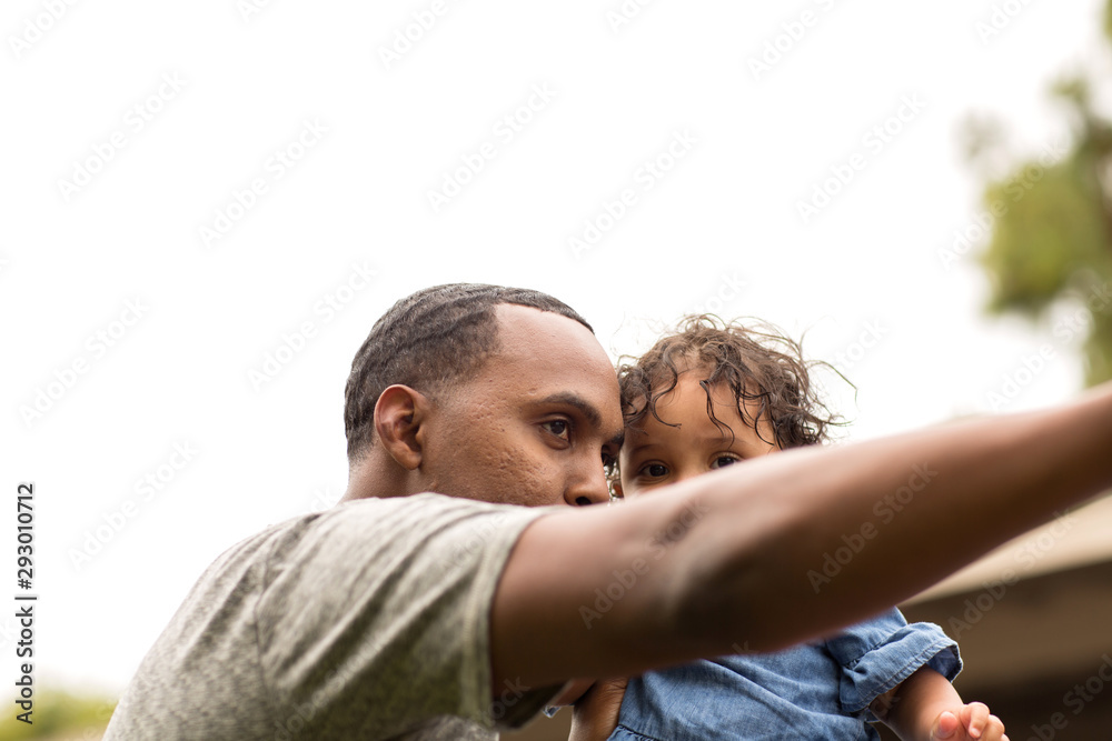 Father holding his little girl. Mixed race family. - obrazy, fototapety, plakaty 
