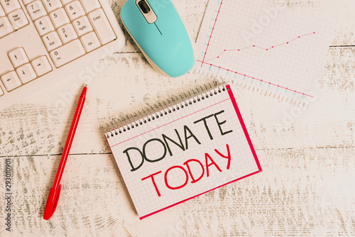 Conceptual hand writing showing Donate Today. Concept meaning time to give money or goods to help a demonstrating or organization Wood desk office appliance computer equipaments charts paper slot photo