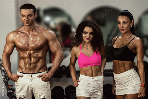 muscular people in gym. sportive men and women in gym. fitness. bodybuilding. gym. group of athletes in gym 