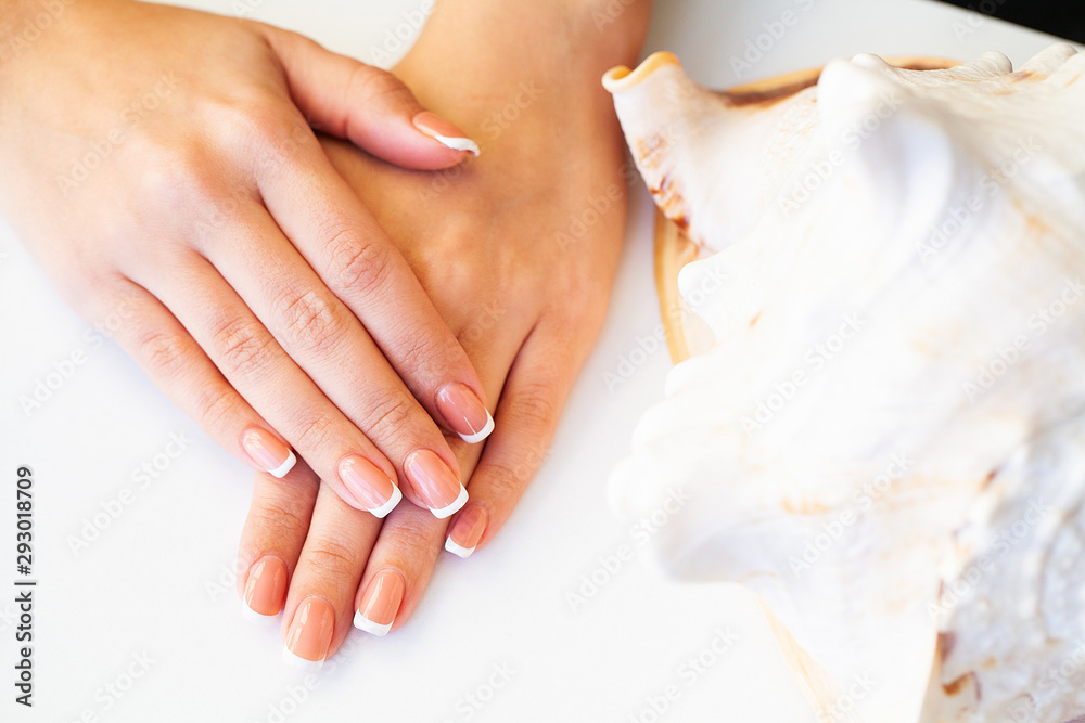 Naklejka premium Beautiful woman's nails with french manicure, in beauty studio