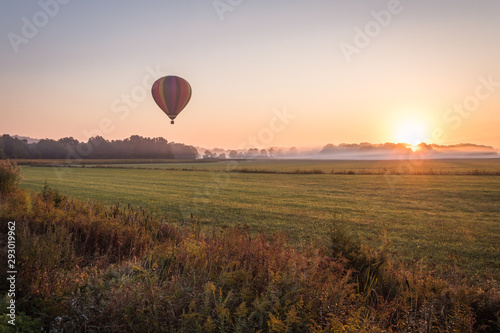 Hot air balloon lifts off over a farm field at sunrise, Pine Island, NY, early fall