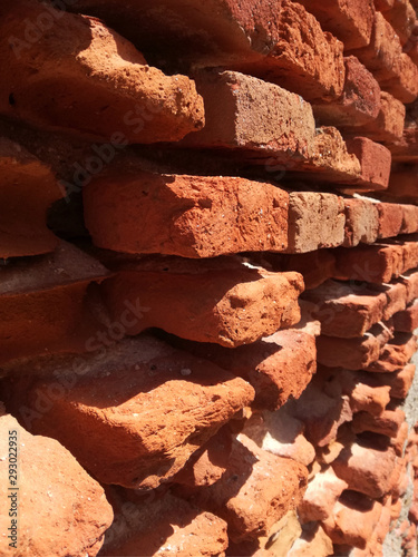 Ancient and genuine wall. Solid red clay brick very old. The wall where the long brick is preserved and the assembly and junction material is eroded. Patches of adobe and white varied chunks. Reddish.