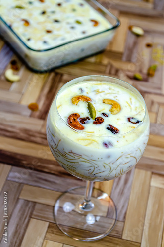 Closeup of Vermicelli Kheer in a Balloon Glass garnished with Cashew, raisins & cardamom. photo