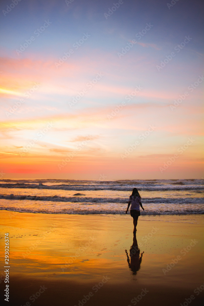 Young woman walking at the beach at sunrise in Ubatuba, Sao Paulo, Brazil
