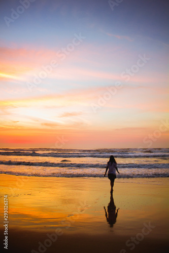 Young woman walking at the beach at sunrise in Ubatuba, Sao Paulo, Brazil © isadora
