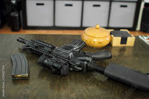 High capacity magazine with bullets next to an AR15 on a table in a home.