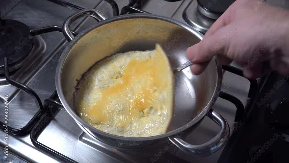 Man flipping omelette with a fork Man flipping omelette with a fork