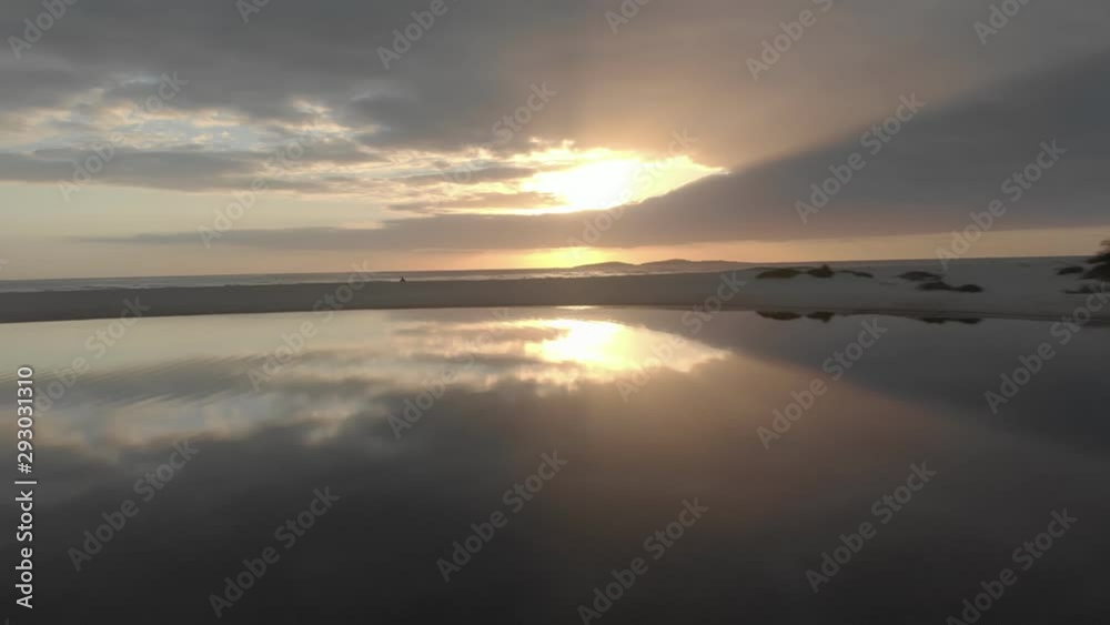 Dramatic dreamlike beach horizon moving over sand & ocean waters mirror reflecting colourful sunbeam skyline. Dramatic dreamlike beach horizon moving over sand & ocean waters mirror reflecting colourful sunbeam skyline.