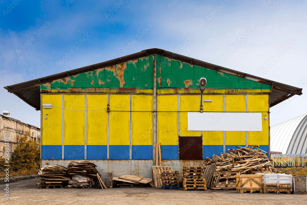 Close-up of the national flag of Gabon. painted on the metal wall of a large warehouse the closed territory on a summer day. The concept of storage of goods, entry to a closed area, tourism Close-up of the national flag of Gabon. painted on the metal wall of a large warehouse the closed territory on a summer day. The concept of storage of goods, entry to a closed area, tourism